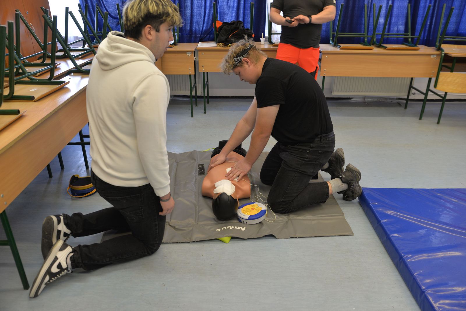 A group practicing CPR and AED skills during a classroom training session